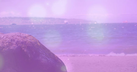 Sitting large textured rock on sandy shoreline, with pastel haze over calm sea, copy space. Seascape, tranquility, abstract, minimalist, nature, serenity, pastelの写真素材