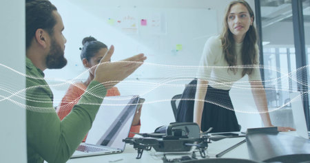 Discussing drone design professionals collaborating in conference room, with VR headset and laptops. Collaboration, innovation, technology, teamwork, modern, brainstorming, digitalの写真素材
