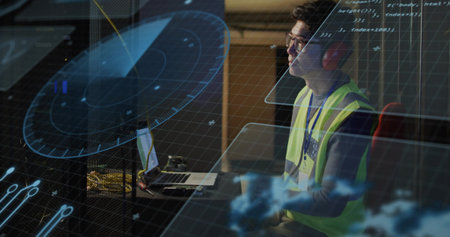 Mature Korean engineer wearing vest monitoring radar overlays on laptop in control hub, copy space....