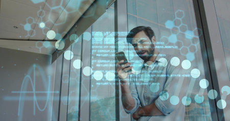 Standing bearded man scanning smartphone in glass hallway, displaying digital overlays, copy space. Futuristic, innovation, technology, corporate, urban, sleek, professionalの写真素材