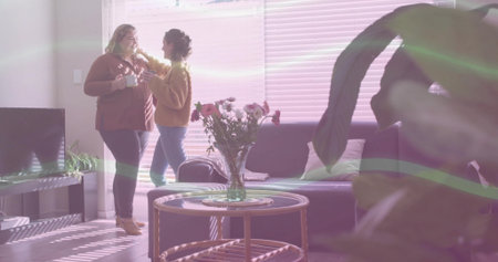 Chatting friends holding white mugs and adjusting hair in living room with coffee table, copy space....