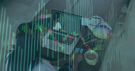 Woman holding credit card scanning stock market graphs on laptop in home office, with color wheel....