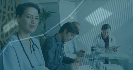 Healthcare team in medical attire reviewing data in hospital office, with stethoscopes and tablet....