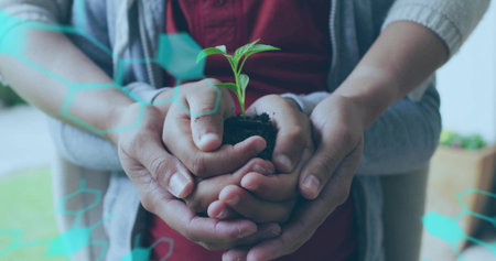 Mother's and son's hands cradling seedling on outdoor terrace, with teal overlay. Growth, nurturing, family, connection, sustainability, eco, tenderの写真素材