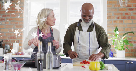 Couple wearing aprons stirring saucepan and slicing bell pepper in home kitchen, with cutting board. Cooking, teamwork, culinary, modern, cozy, healthy, lifestyleの写真素材