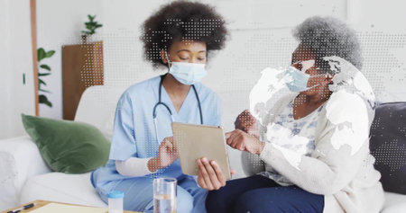 Nurse in scrubs and patient reviewing tablet in living room, with prescription bottle and clipboard. Healthcare, telemedicine, domestic, professional, technology, wellness, communicationの写真素材