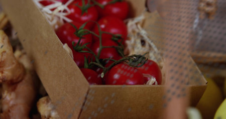 Displaying cherry clusters on vine in cardboard crate on wood shavings with ginger root pieces. Fresh produce, farm-fresh, organic, rustic, natural, vibrant, healthyの写真素材