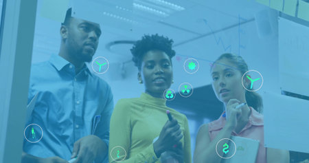 Brainstorming team analyzing glass board in office area, with markers and colorful sticky notes. Collaboration, innovation, teamwork, brainstorming, strategy, creative, productivityの写真素材