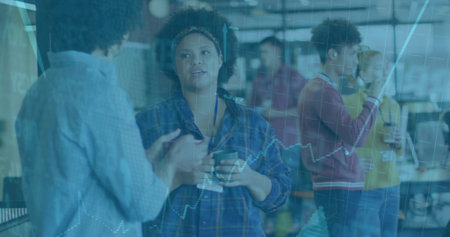 Discussing woman holding coffee mug in open plan office with smartphone glass wall overlays. Collaboration, teamwork, data analysis, corporate, workplace, modern, communicationの写真素材