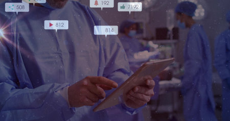 Holding tablet doctor monitoring patient data under surgical lights in OR. Medical collaboration,...