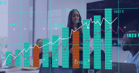 Presenting businesswoman showing bar charts on transparent display in conference room, with laptops....