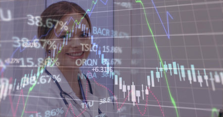 Standing doctor wearing lab coat and stethoscope analyzing financial overlay in clinic, copy space. Medical, healthcare, analytics, digital, professional, innovation, consultingの写真素材