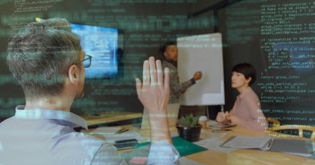 Raising hand team lead wearing collared shirt discussing code in conference room, with flip chart....