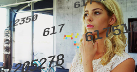 Standing woman gazing in office with bicycle by accent wall, sticky notes and numeric overlays. Contemporary, innovation, workspace, digital, creative, ergonomics, urbanの写真素材