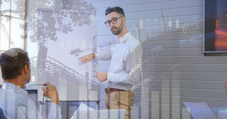 Standing professional presenting charts on whiteboard in meeting room with documents and monitor. Business, teamwork, analysis, modern, corporate, collaboration, communicationの写真素材