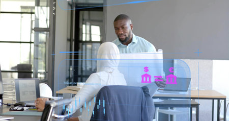 Presenting man showing financial sheet to seated headscarfed woman in modern office. Corporate, collaboration, data visualization, professional, workspace, analytics, teamworkの写真素材