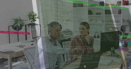 Developers in striped blouse and blue shirt reviewing code on monitor in office, with laptop. Collaboration, programming, technology, workplace, innovation, productivity, modernの写真素材