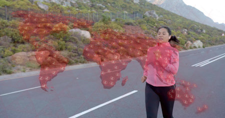 Jogging Asian woman in sportswear along paved mountain road with fence, map overlay, copy space. Outdoors, fitness, adventure, technology, resilience, exploration, landscapeの写真素材