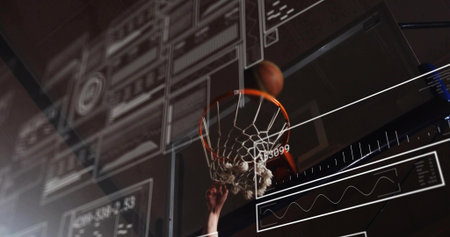 Leaping basketball athlete gripping rim and dunking ball on court, showing floating digital panels. Sport, athleticism, technology, performance, fitness, training, data visualizationの写真素材
