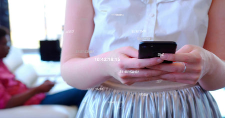 Holding smartphone, woman in white blouse, silver skirt scrolling apps in living room, with windows. Technology, communication, lifestyle, elegance, relaxation, modernity, interiorの写真素材