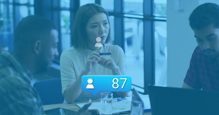 Central businesswoman listening in meeting room, with laptops printed charts pens water glasses. Professional, teamwork, collaboration, modern, corporate, discussion, strategydesignの写真素材