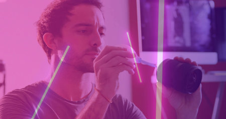 Adjusting camera technician repairing lens at neon-lit studio, with screwdriver, copy space. Studio,...