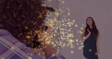 Man holding DSLR camera photographing model in black dress against backdrop with bokeh, copy space. Portrait, professional, minimalist, fashion, lighting, elegance, artistryの写真素材