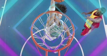 Soaring athlete wearing jersey dunking ball through netted hoop on neon-lit court. Action,...