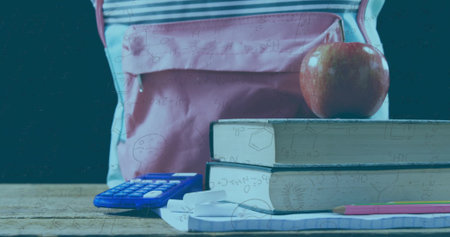 Displaying light pink backpack nestling behind school supplies on desk with red apple and earphones. Stationery, education, classroom, learning, organization, study, youthの写真素材