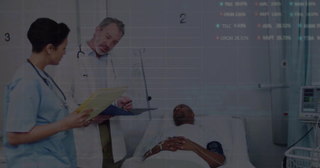 Physician in white coat and nurse in scrubs reviewing patient file in hospital, with IV stand....