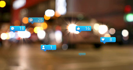 Floating blue notification icons over blurred city street at night, showing social media counts. Technology, urban, nightlife, digital, vibrant, motion, connectivityの写真素材