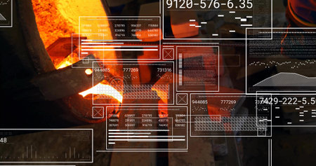Worker in heat suit pouring molten metal from crucible into mold at foundry, with digital panels....
