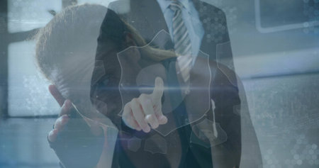 Pointing blazer-clad businesswoman accessing holographic shield icon at office, with hex overlays. Cybersecurity, data protection, digital interface, modern workspace, high-tech, corporate technology, teamworkの写真素材