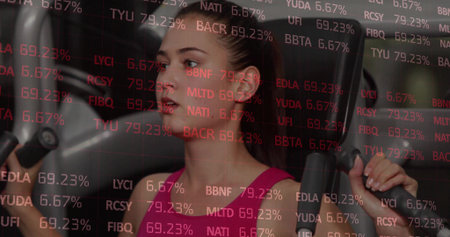 Gripping handles, female exerciser wearing pink top using weight machine in gym, red ticker overlay. Fitness, strength, training, wellness, health, motivation, modernの写真素材