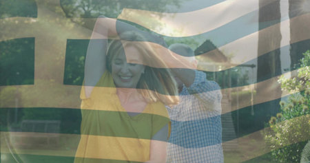 Dancing senior man and adult woman twirling on paved garden path, with benches and stone steps. Romantic, outdoor, vintage, movement, happiness, leisure, greeneryの写真素材