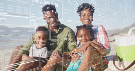 Sitting family of four holding children together on sandy beach shoreline, with portable cooler. Family, togetherness, relaxation, outdoor, leisure, vacation, harmonyの写真素材