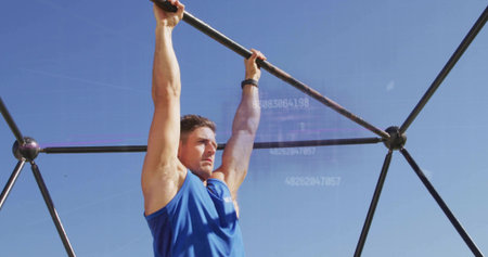 Hanging male athlete gripping metal frame in outdoor rig, wearing shirt and watch with data overlay....