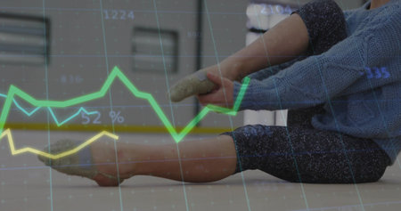 Stretching sweater clad girl in patterned leggings grasping feet on mat at gym showing data overlay. Fitness, children, activewear, progress, analysis, wellness, postureの写真素材