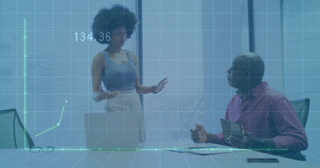 Analyzing finance data at table team wearing work attire with laptop projected chart reading 134.36. Business, collaboration, analytics, professional, modern, technology, innovationの写真素材