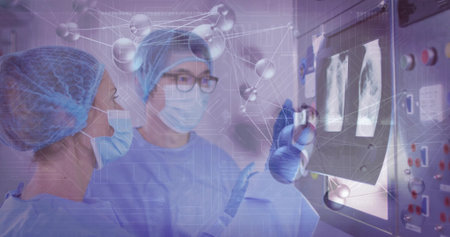 Pointing surgeon and assistant wearing scrubs at console in hospital lab, with molecular overlay. Medical, diagnostic, healthcare, technology, innovation, clinical, examinationの写真素材