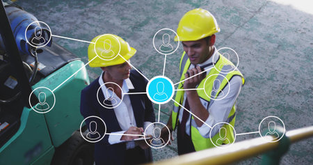 Site workers in hard hats, vests chatting in yard with forklift radio and network icons. Construction, teamwork, industrial, digital, communication, management, infrastructureの写真素材