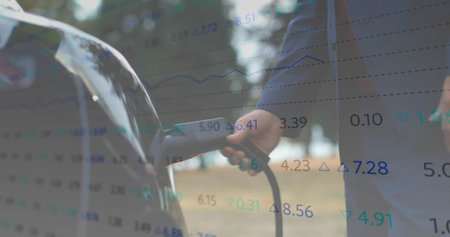 Connecting driver wearing dark shirt inserting EV connector into car charging port at park. Sustainability, innovation, eco-friendly, technology, renewable, environment, efficiencyの写真素材