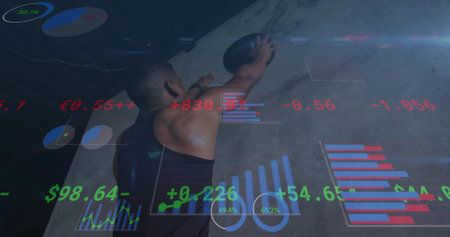 Athlete in tank top lifting medicine ball overhead against gym wall, with holographic charts. Strength, determination, innovation, digital, fitness, motivation, modernの写真素材