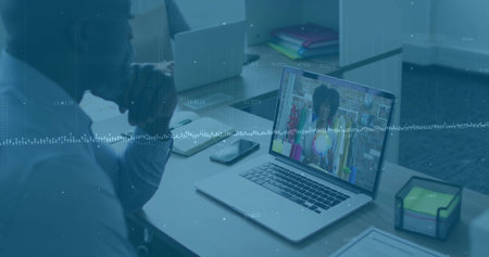 Consultant listening to shop owner via laptop in office, smartphone notebook sticky note cube. Professional, collaboration, remote, communication, modern, technology, productivityの写真素材