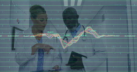 Reviewing data, doctors analyzing in hospital corridor, with tablet, stethoscopes and graph overlay....