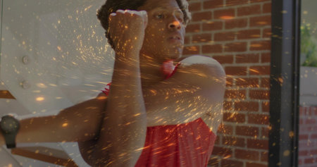 Stretching man in red tank top pulling arm across chest at gym, with smartwatch and rig. Fitness, training, wellness, physical activity, urban studio, motivating, dynamicの写真素材