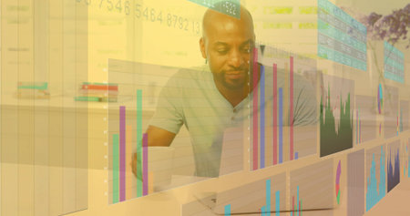 Analyst wearing polo shirt analyzing financial holographic charts in office with laptop notebook....