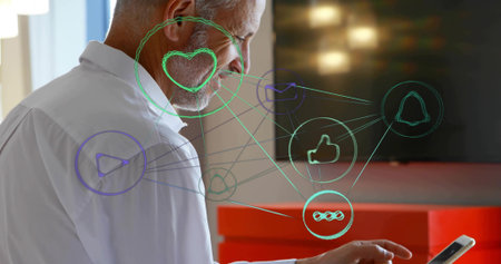 Interacting senior man in white shirt tapping smartphone at office desk, with floating social icons. Technology, connectivity, modern, workplace, professional, digital, communicationの写真素材