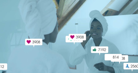 Woman in white bathrobe and turban touching cheek in bathroom mirror, showing floating social icons. Reflection, wellness, self-care, serenity, minimalism, relaxation, vanityの写真素材