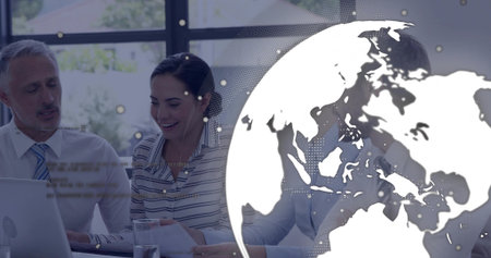 Reviewing business professionals collaborating at meeting table in office with laptop and reports. Corporate, teamwork, communication, modern, strategy, analysis, brainstormingの写真素材